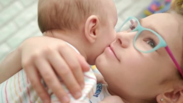 Lovely baby in sister hug. Close up of happy girl hugging younger brother — Stock Video