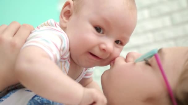 Glückliches Mädchen küsst Baby Boy. Nahaufnahme von Mädchen umarmen Säugling — Stockvideo