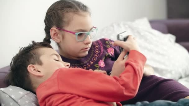 Kinderen gebruiken smartphone thuis. Close-up van de kinderen op zoek naar moderne modile telefoon — Stockvideo