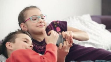 Çocuklar evde Smartphone için mücadele. Kız ve erkek kardeş cep telefonu paylaşın değil
