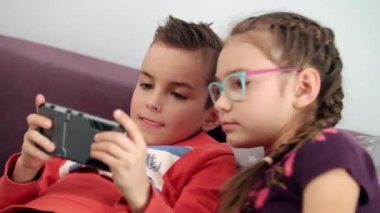 Çocuklar evde cep telefonu kullanma. Çocuk elinde smartphone bakarak kardeş