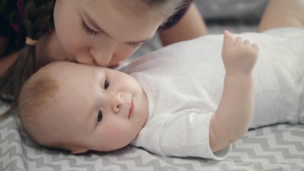Hermana beso adorable hermanito. primer plano de chica precioso beso bebé chico cara — Vídeo de stock