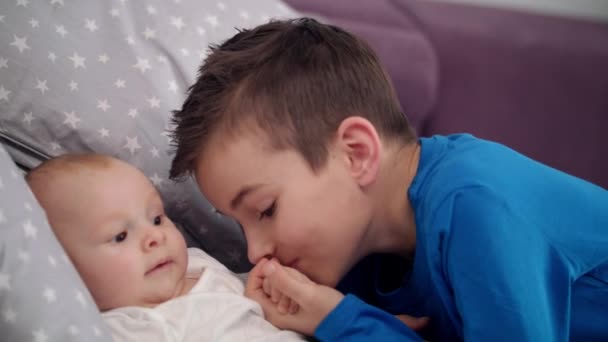 Älterer Bruder küsst Baby Hand. liebenswerte Brüder lieben Konzept — Stockvideo