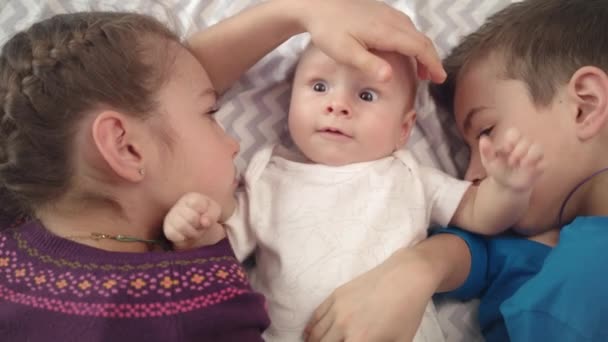 Fröhliche Kinder kümmern sich um Baby. entzückendes Kinderporträt. schönes Säuglingsgesicht — Stockvideo