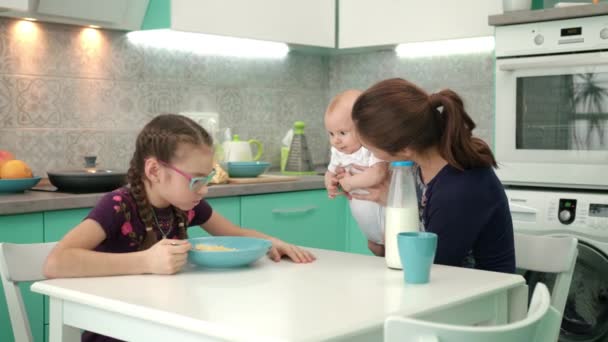 Familienfrühstück am Morgen. Mädchen isst Cornflakes mit Milch am Küchentisch — Stockvideo