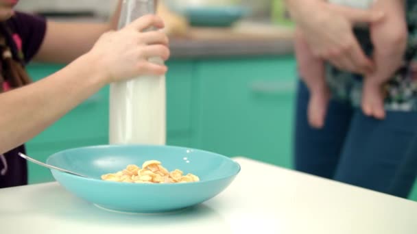Κορίτσι ρίχνει γάλα σε γυάλινο μπολ νιφάδες καλαμποκιού. Υγιεινός τρόπος ζωής — Αρχείο Βίντεο