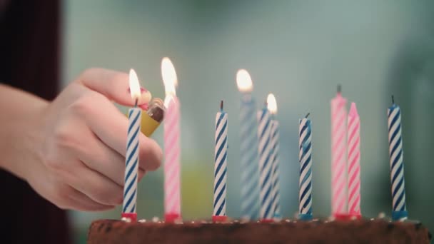 De cake van de kindverjaardag met kaarsen. Vrouwelijke hand kaars brand met lichtere vlam — Stockvideo