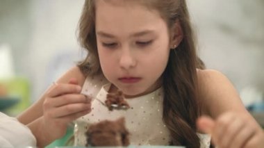 Güzel kız çikolatalı kek yeme. Doğum günü pastası yemek çocuk portresi