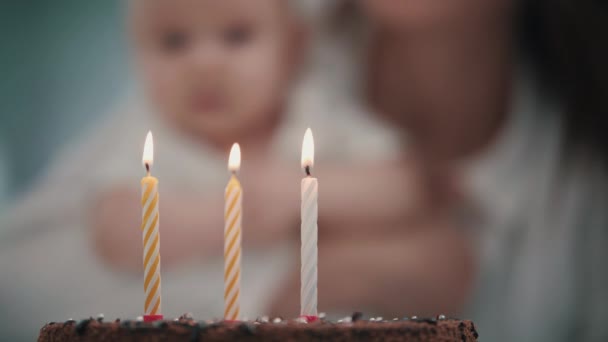 Mother blowing three candles at baby birthday cake. Baby birthday party concept — Stock Video