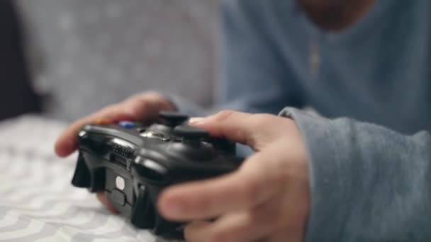 Uma mão de rapaz a jogar joystick. Fechar a mão da criança segurando joystick jogo de vídeo — Vídeo de Stock
