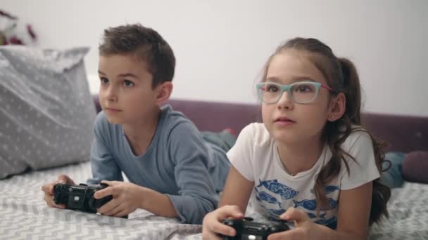 快乐的孩子在家里赢得电子游戏。玩电子游戏的男孩和女孩 — 图库视频影像