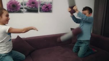 Kız ve erkek kardeşim yastık mücadele. Kardeşleri kavga yastık. Çocuk birlikte eğlenelim
