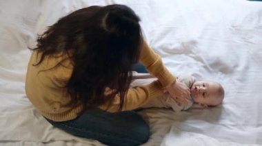 Genç bebek için egzersizleri güçlendirilmesi yapıyor anne. Çocuk ile oynayan kadın