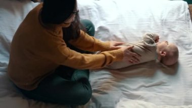Genç kadın Masaj erkek bebek evde. Mutlu kadın küçük çocukla oynuyor
