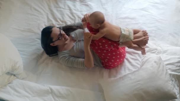 Neugeborenes auf den Beinen der Mutter liegend. Baby-Training. Kinderpflege zu Hause — Stockvideo