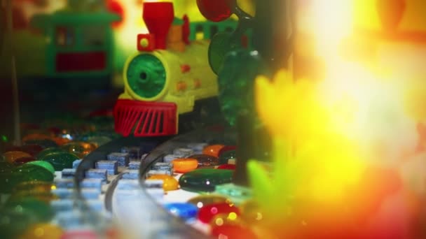 Colorful toy train moving by rails on camera. Close up kids railroad — Stock Video