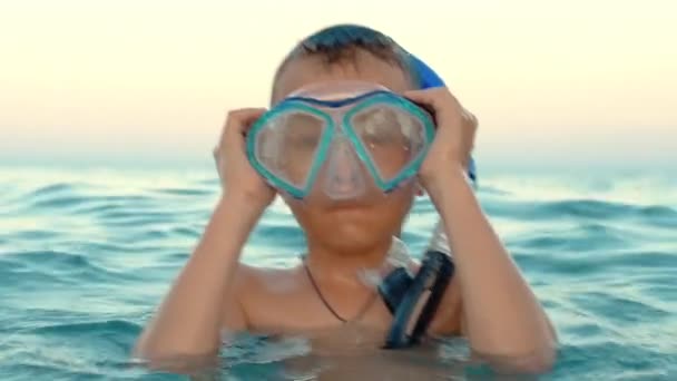 Boy putting on diving mask and snorkel. Child preparing for diving into sea — Stock Video