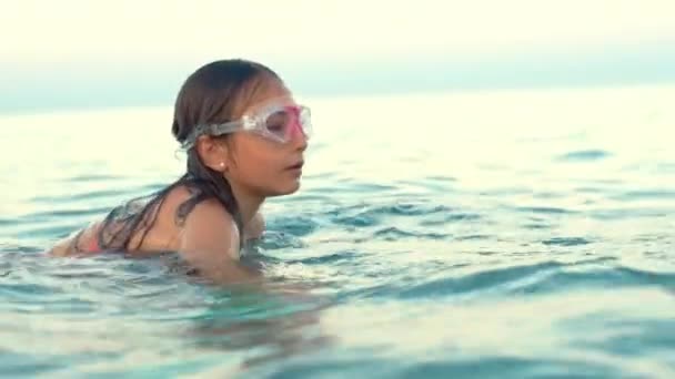 Девушка в водолазной маске плавает под водой в море. Уроки плавания — стоковое видео