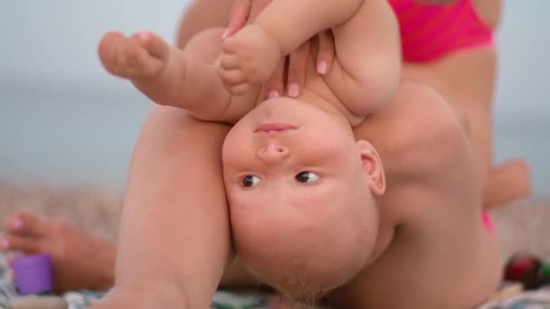 Madre y bebé jugando en la playa. Mamá y el niño en la playa en las vacaciones de verano — Vídeos de Stock