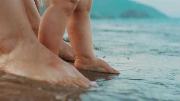 Madre e piedi del bambino in piedi sulla spiaggia. Vacanze estive in famiglia — Video Stock