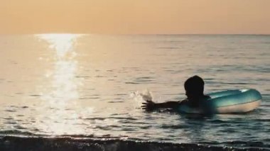 Kauçuk halka su yaz tatillerinde denizde oynayan küçük çocuk