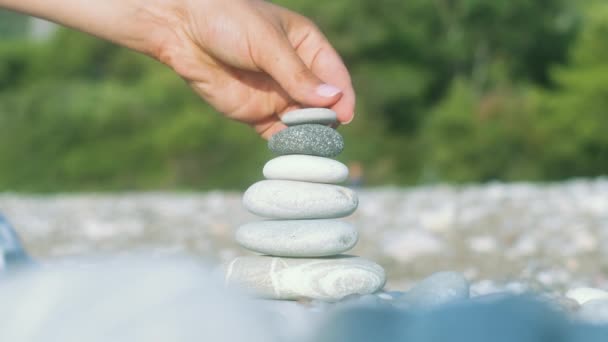 Рука робить баланс каменю на морському пляжі. Концепція духовної гармонії — стокове відео
