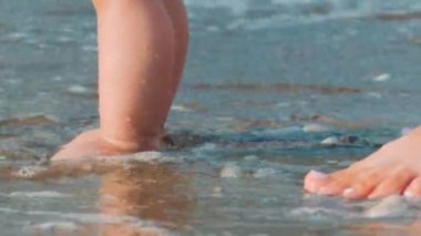 Anne ve bebek ayak Kum Plajı üzerinde yürüme. Yeni doğan çocuğun ayak Beach