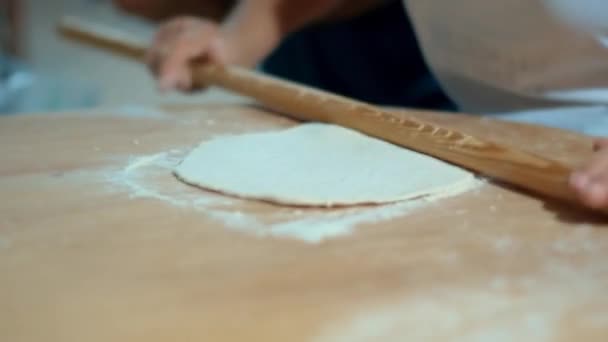 Human hands with rolling pin roll out piece of dough. Cooking bakery products — Stock Video