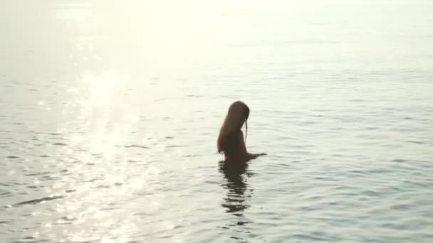 Dziewczynka stoi w morze wieczorem. Dziewczyna mycia maska do nurkowania w morzu — Wideo stockowe