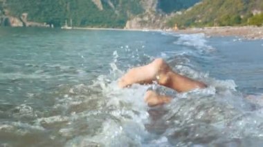 İnsan ayakları splash su deniz plaj yavaş çekimde. Alt bacaklar dalgalar dövdü