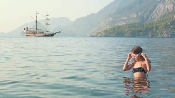 Junges Mädchen in Tauchermaske schwimmt unter Wasser im Meer. Kleines Mädchen taucht im Meer — Stockvideo