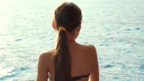 Mladá dívka hledá při plavbě na jachtě na moři. Dívka pohledu na moři — Stock video