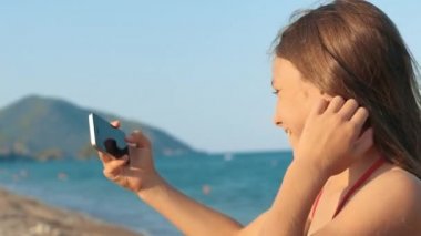 Küçük kız selfie deniz kıyısı, yapım telefon kamera önünde poz