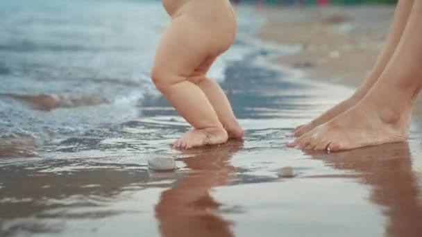 Μητέρα και το μωρό το πόδι περπάτημα στην παραλία με άμμο. Νεογέννητο παιδί πόδια στην παραλία — Αρχείο Βίντεο