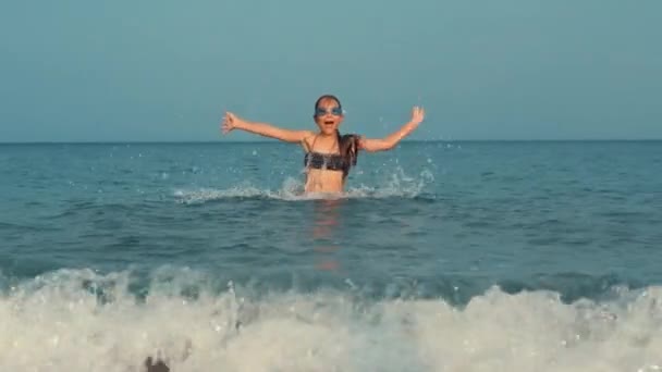 Mladá dívka skákání v mořské vodě. Teenager baví plavání v oceánu — Stock video