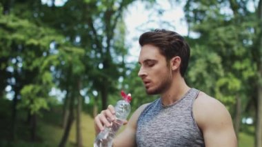 Spor adam içme suyu yaz parkta egzersiz çalıştırdıktan sonra şişe