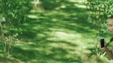 Yaz Park'ta jogging, mobil uygulaması sonuçlarında kontrol neşeli kadın runner