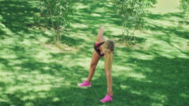 Spor kadın yaz parkta egzersiz sırasında germe egzersiz yapmak. Uygun kadın