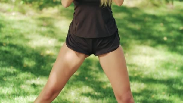 Sportovní žena dělá squat cvičení v městském parku na venkovní trénink. Fitness žena — Stock video