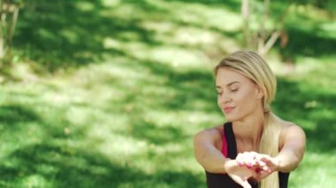 Kadın bodur tatbikat Şehir Parkı içinde gülümseyen. Kadın egzersiz ısınma yapıyor