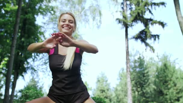 Uśmiechnięta kobieta robi squat ćwiczenia na rozciąganie nogi przed fitness odkryty — Wideo stockowe