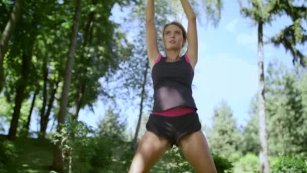 Sportlerin springt vor Vormittagstraining im Stadtpark — Stockvideo