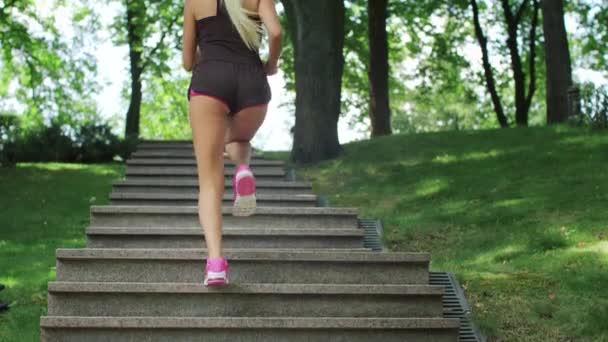 Fitness woman running up stairs while morning jogging at summer park — Stock Video