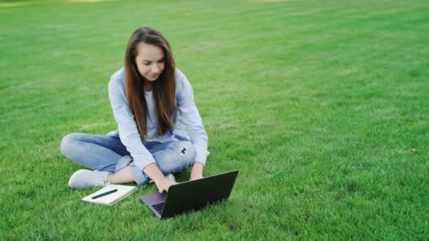 Γυναίκα φοιτητής εργάζεται στον φορητό υπολογιστή στην πανεπιστημιούπολη colledge. Δουλειά freelance — Αρχείο Βίντεο