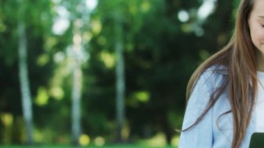 Yaz günü Şehir Parkı içinde dizüstü bilgisayar üzerinde çalışan gülümseyen kadın