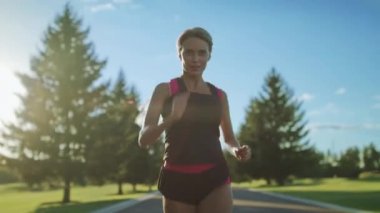 Ağır çekimde çalışan kadın atlet. Park yolu üzerinde çalışan spor kadın