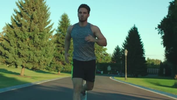 Atleta hombre corriendo en el parque de la ciudad mientras que el entrenamiento cardiovascular al aire libre. Estilo de vida deportivo — Vídeos de Stock