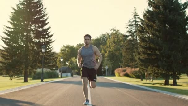 Allenamento corridore maschile per correre maratona nel parco. Sport uomo esercizio all'aperto — Video Stock