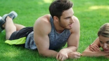 Spor insanlar açık eğitimden sonra rahatlatıcı. Erkek ve kadın yeşil çim üzerinde yalan