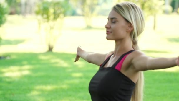 Lachende vrouw beoefenen van yoga oefening in zomer park. Fitness een levensstijl — Stockvideo